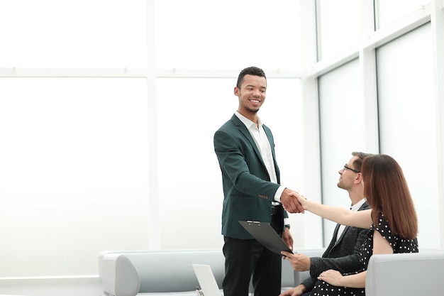 Smiling Manager accueille les clients dans le hall du bureau