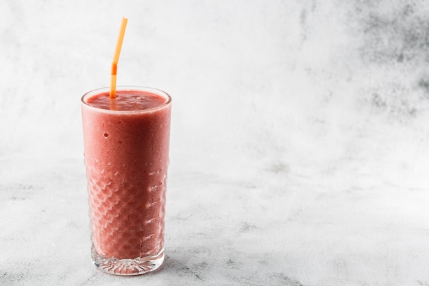 Smoothie aux baies ou rose framboise, milk-shake rouge en verre sur fond de marbre brillant. Vue aérienne, espace copie. Publicité pour le menu du café milkshake. Menu du café. Photo horizontale.