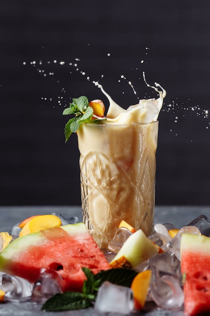 Smoothie aux baies avec des tranches de fruits qui tombent