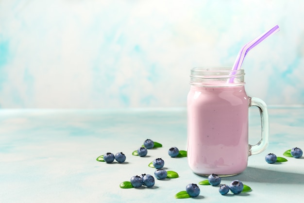 Smoothie aux bleuets dans un verre sur une table rustique.