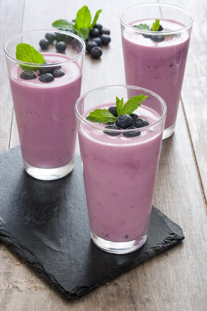 Smoothie aux bleuets frais dans des verres sur bois rustique