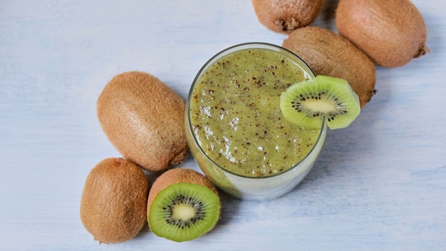 Photo smoothie aux fibres de kiwi sur fond blanc avec des kiwis autour vu d'en haut