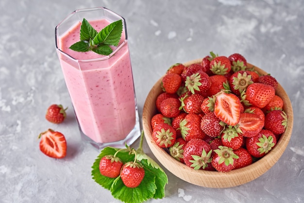 Smoothie Aux Fraises Dans Un Bocal En Verre Et Des Fraises Fraîches Dans Un Bol En Bois Sur Fond Gris. Petit-déjeuner Sain