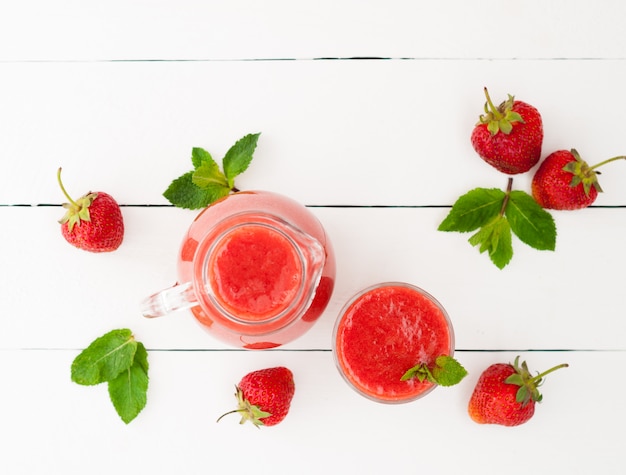 Smoothie aux fraises fraîches à la menthe sur un fond en bois blanc rustique. Aliments sains. Mise au point sélective