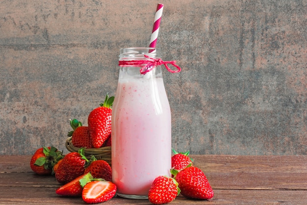 Smoothie aux fraises ou milkshake dans une bouteille avec de la paille