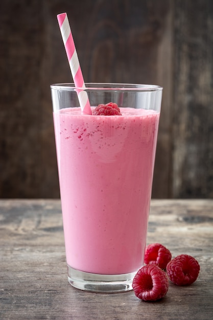 Smoothie aux framboises en verre sur table en bois