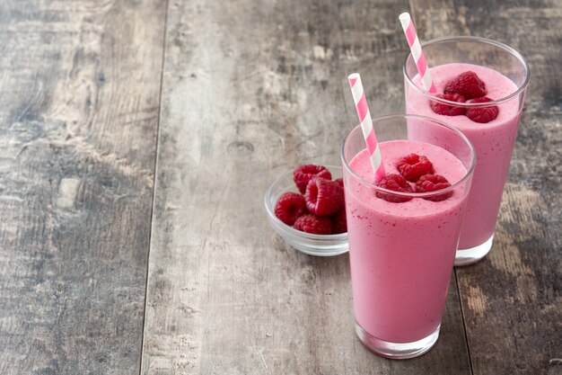 Smoothie aux framboises en verre sur table en bois