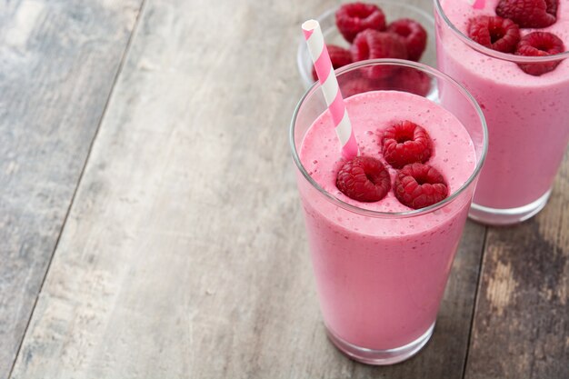 Smoothie aux framboises en verre sur table en bois