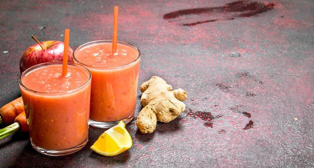 Smoothie aux fruits dans des verres. Sur fond rustique.