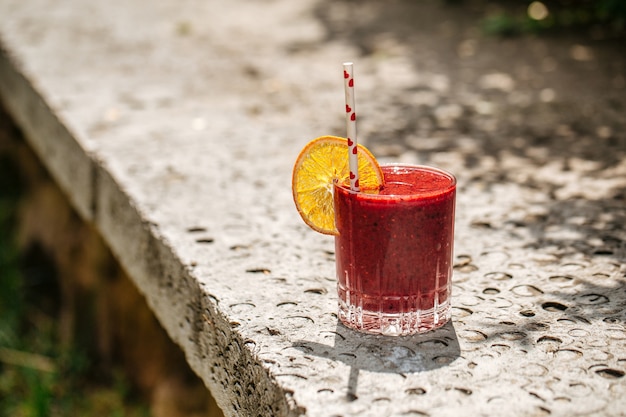 Smoothie aux fruits rouges dans un verre avec une paille