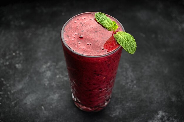 Smoothie aux fruits sucrés sur fond sombre