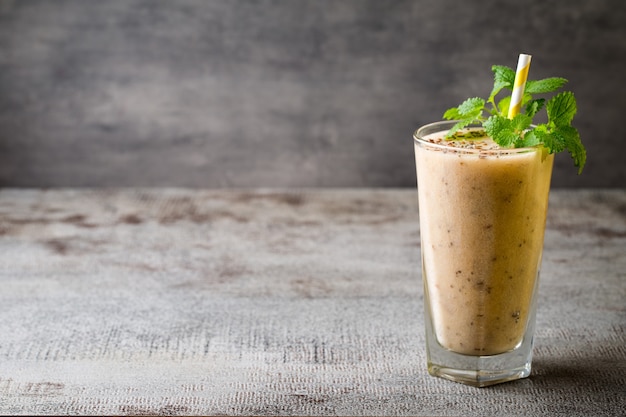 Smoothie banane et citron, sur la table grise.