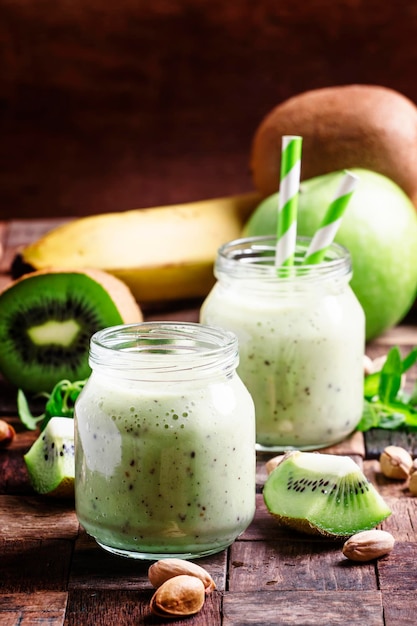 Smoothie avec banane kiwi et noix vieille mise au point sélective sur fond de bois