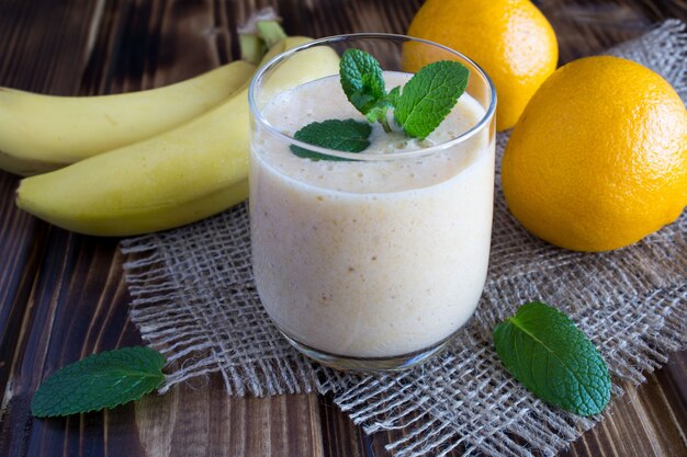 Smoothie de banane et mandarine sur la surface en bois rustique