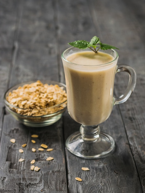 Smoothie à base de flocons de banane et d'avoine sur une table en bois