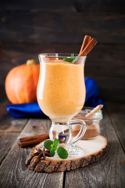 Smoothie à la citrouille avec cannelle et granola sur l'ancienne surface en bois. Mise au point sélective.