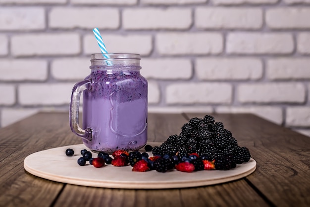 Smoothie frais au yaourt fait maison de baies sauvages dans un bocal en verre sur un vieux millésime, gros plan, mise au point sélectionnée. Récolte .