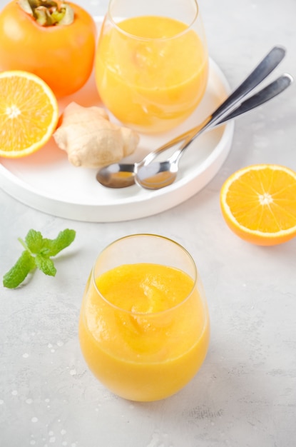 Smoothie frais et sain avec kaki, orange et gingembre.