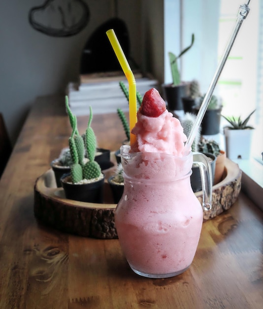 Un smoothie à la fraise sur une table en bois