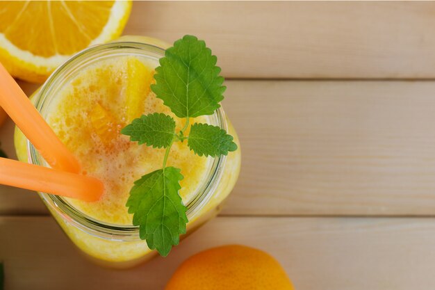 Smoothie jaune de boisson saine avec des tranches d'orange juteuses