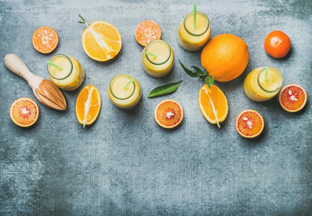 Smoothie jaune sain en bouteilles sur la vue de dessus de fond en béton