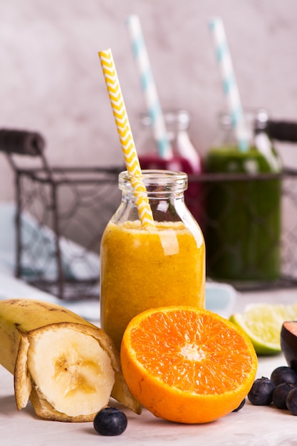 Smoothie jaune sucré sain dans une petite bouteille en verre