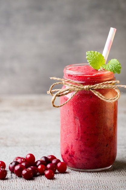 Smoothie, jus rose sur fond gris.