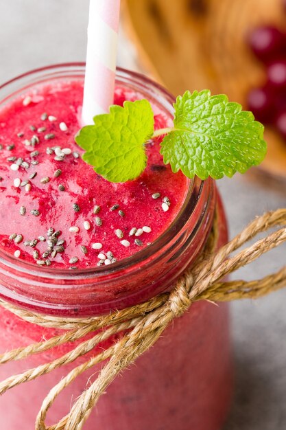 Photo smoothie, jus rose sur fond gris