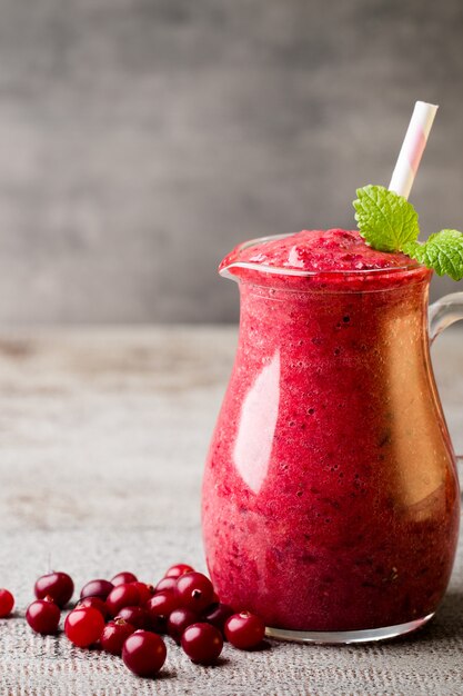 Smoothie, jus rose sur la table grise.