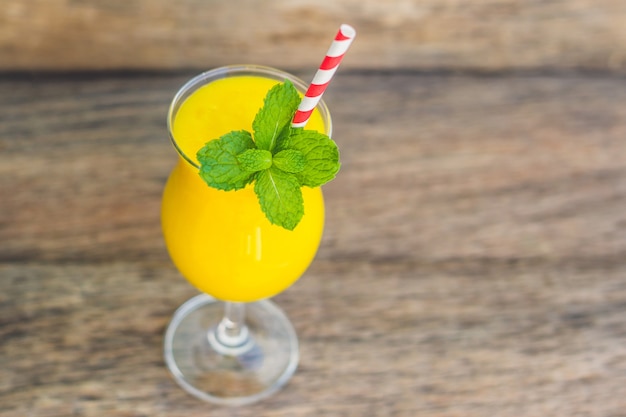 Smoothie juteux de mangue en verre avec paille rayée