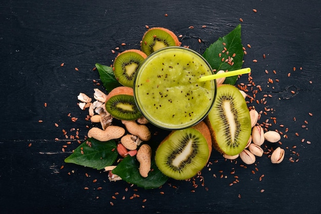 Smoothie kiwi aux graines de lin et aux noix Sur un fond en bois Vue de dessus Espace libre pour votre texte