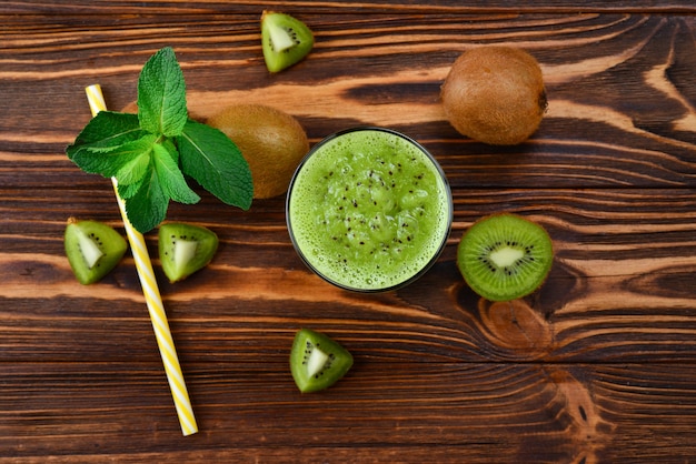 Smoothie kiwi frais en bonne santé en verre sur bois