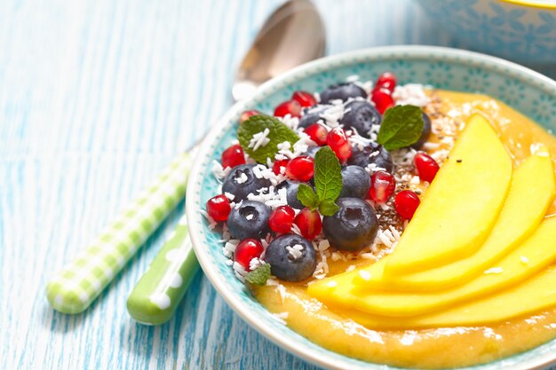 Smoothie à la mangue et à la banane avec garniture de baies dans un bol