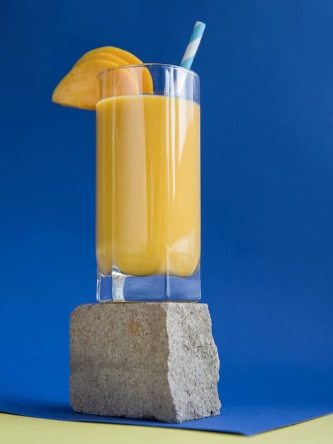 Smoothie à la mangue sur fond bleu