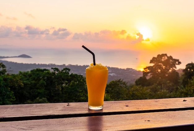 Smoothie à la mangue sur le fond du magnifique coucher de soleil et de la mer depuis le point de vue de l'île de Koh Samui en Thaïlande