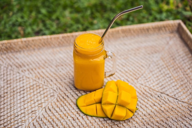 Photo smoothie à la mangue et paille en acier sur fond de paille