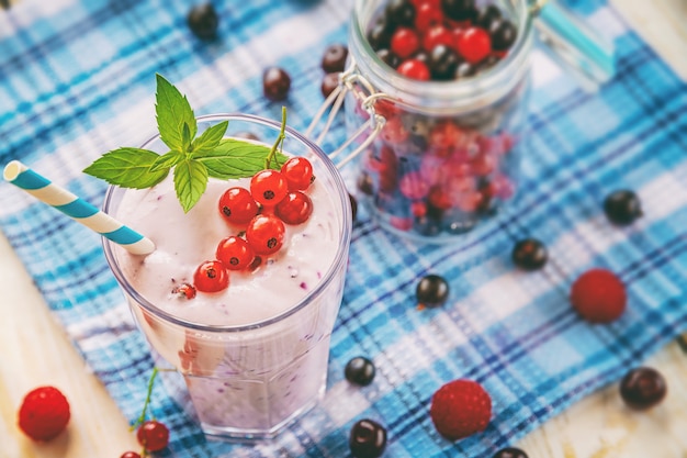 Smoothie milkshake sans alcool avec feuilles de cassis frais, framboise et menthe sur un fond en bois, cocktails de remise en forme et nourriture, produits naturels biologiques