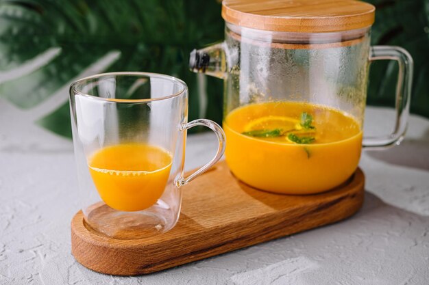 Photo smoothie d'orange fraîchement mélangé dans un verre et une cruche