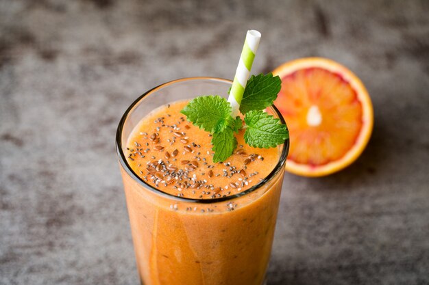 Smoothie, orange rouge, décor de feuilles de menthe.