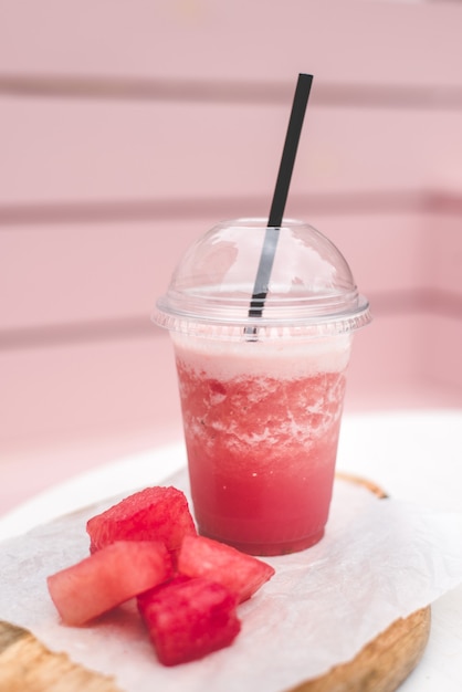 Photo smoothie à la pastèque fraîche. gâterie végétarienne pour toute la famille. verre fermé avec paille noire