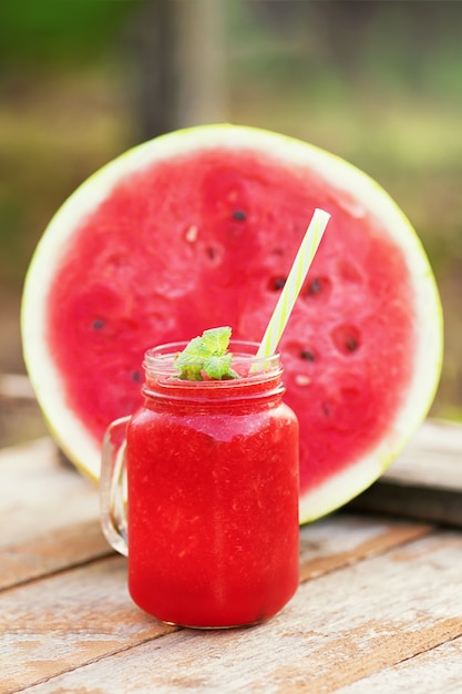 Smoothie pastèque sain sur une vieille surface en bois dans le jardin, selective focus