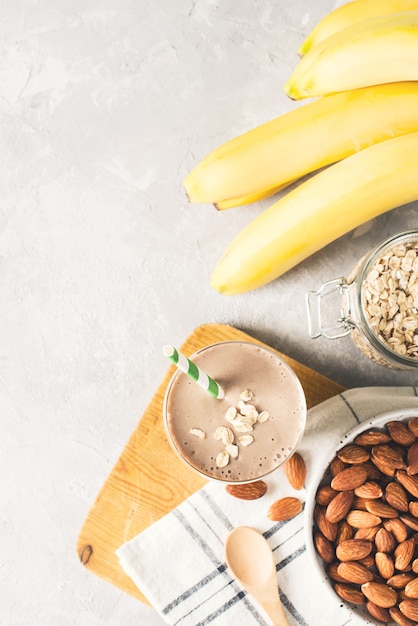 Smoothie petit-déjeuner sain au lait d'amande à l'avoine et à la banane sur blanc