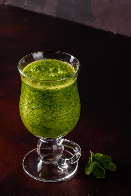 Smoothie pomme verte au gingembre sur fond de béton.