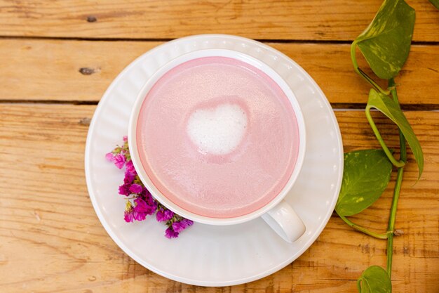 Smoothie rose dans une tasse blanche avec un cœur en mousse au milieu