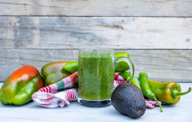 Un smoothie sain enveloppé d'une serviette et de légumes verts