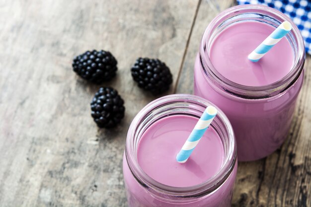 Smoothie sain de mûre en verre sur la table en bois