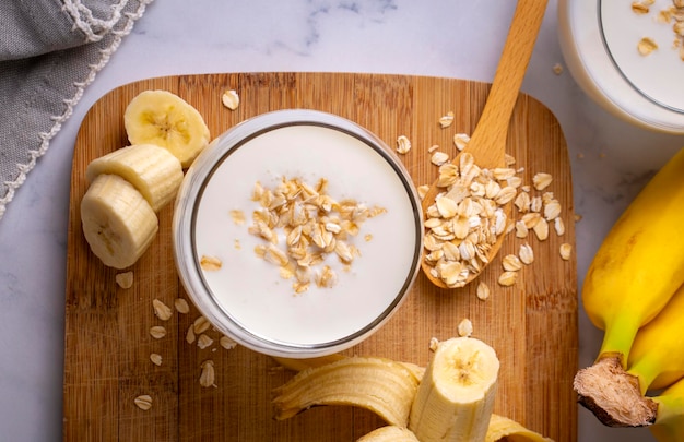 Smoothie végétalien à la banane et à l'avoine dans un pot en verre sur un fond clair Aliments sains