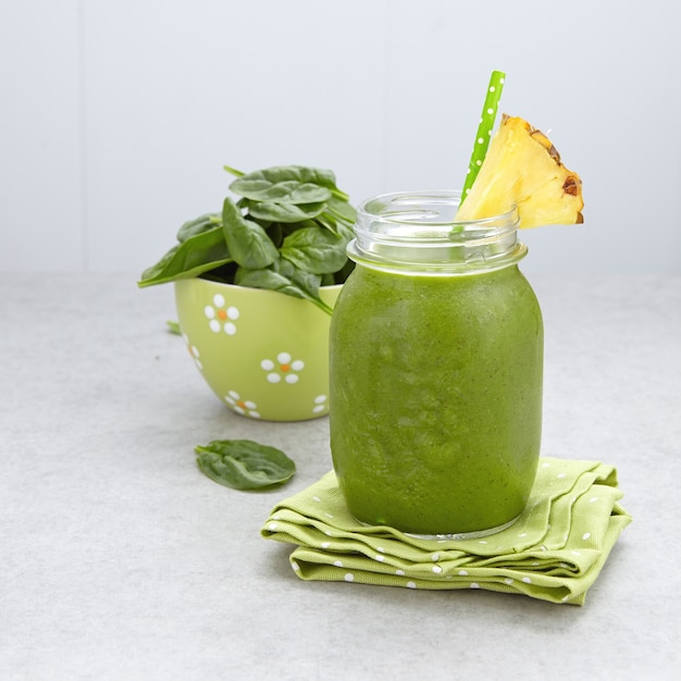 Smoothie vert aux épinards garni d'une tranche d'ananas