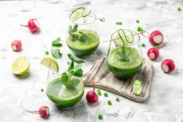 Smoothie vert à base de petits pois bio verts, concombre, radis, épinards et citron vert. Boisson détox saine. vue de dessus.