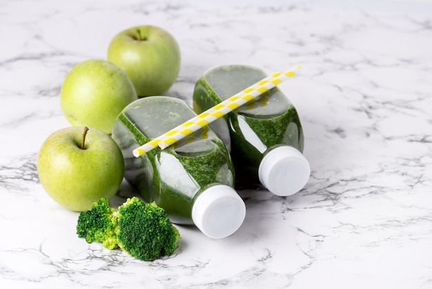 Smoothie vert détox sain avec des pommes vertes et du brocoli mûr en bouteilles Boisson alimentaire saine